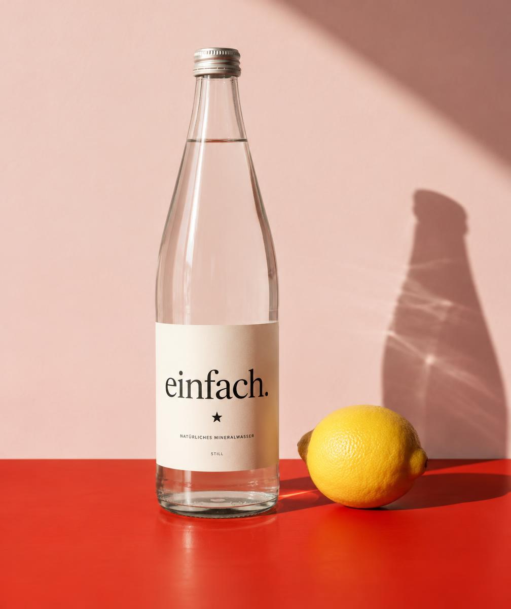 Freie Produktstudie einer Wasserflasche mit der Aufschrift einfach. auf rotem Untergrund